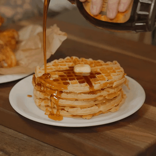 Syrup Is Being Poured On A Stack Of Waffles With Butter GIF