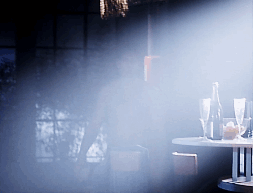 Table With Glasses And Bottle In Dark Room GIF