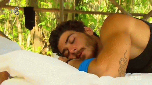 Tattooed Man Sleeping on Bed