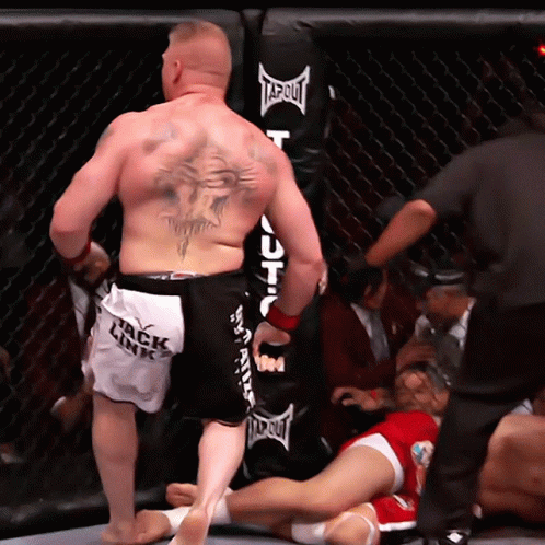 Tattooed Man Standing Before Punching Bag