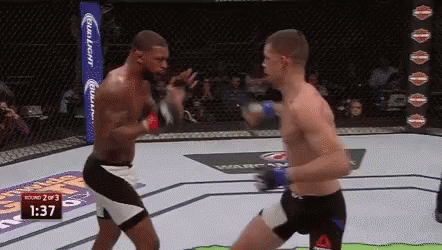 Tattooed Man Standing Before Tapout Punching Bag
