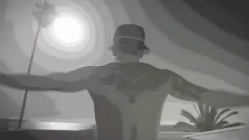 Tattooed Man Standing with Arms Out