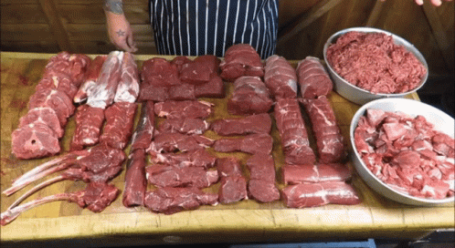 Tattooed Person Standing by Meat Table