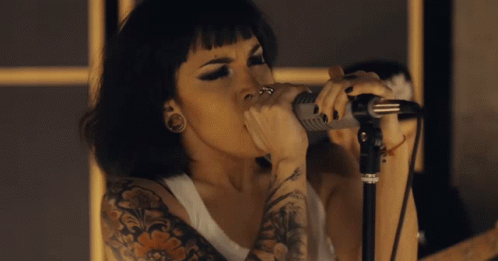 Tattooed Woman Singing Into Microphone