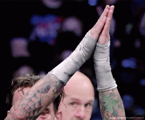Tattooed Wrestler High Fiving Opponent