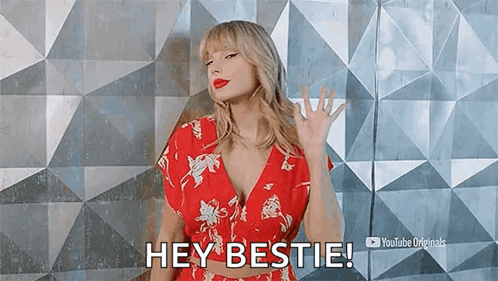 Taylor Swift Is Wearing A Red Floral Dress And Waving At The Camera . GIF