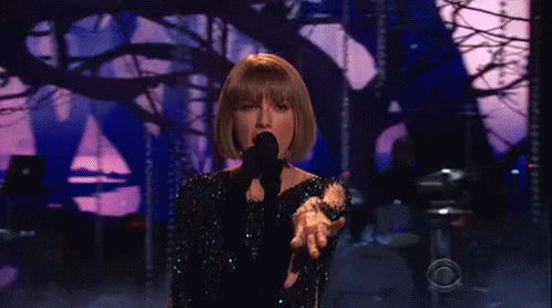 Taylor Swift Singing Into Microphone on Stage
