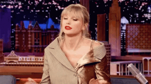 Taylor Swift Sitting at Microphone on Stage