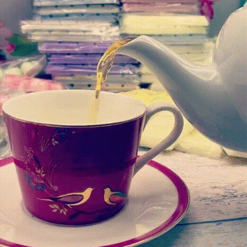 Tea Is Being Poured Into A Cup With Birds On It GIF