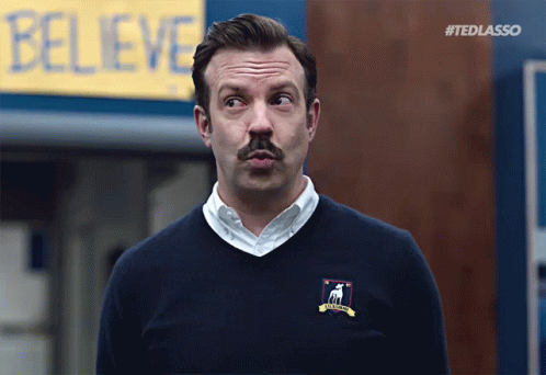 Ted Lasso Peeks At Believe Sign GIF