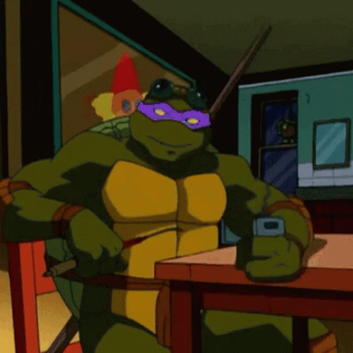 Teenage Mutant Ninja Turtle Sitting at Table With Cell Phone