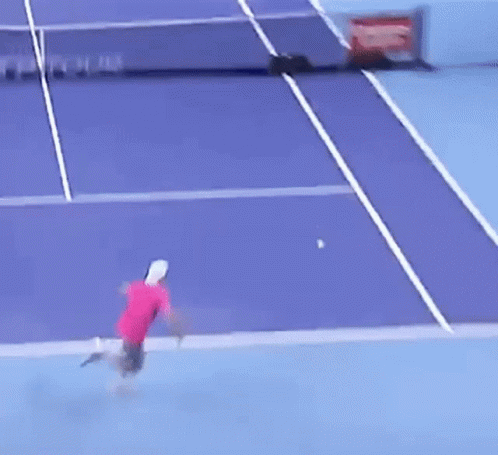 Tennis Player Hitting Ball on Purple Court With Tour on Net