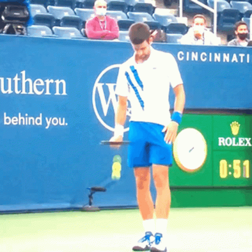 Tennis Player Holding Racquet in Front of Rolex Sign