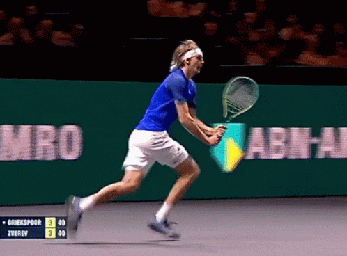 Tennis Player in Blue Shirt and White Shorts Running with Racquet
