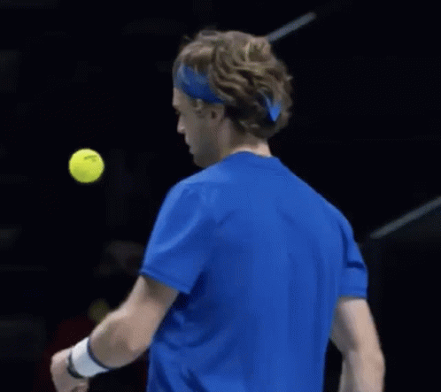 Tennis Player in Blue Shirt Hitting Ball