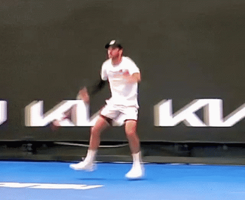 Tennis Player Jumping in Air on Blue Court