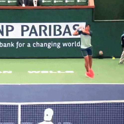 Tennis Player Jumping In Front Of Paribas Sign GIF