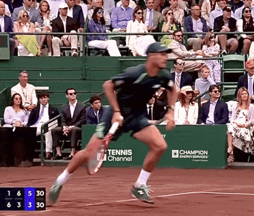 Tennis Player Running on Court in Front of Tennis Channel Banner