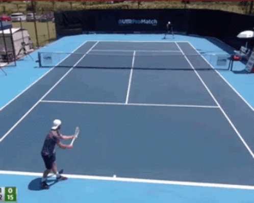 Tennis Player Swinging Racket in Front of Telcel Sign