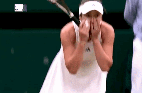 Tennis Player Wiping Face While Holding Racquet
