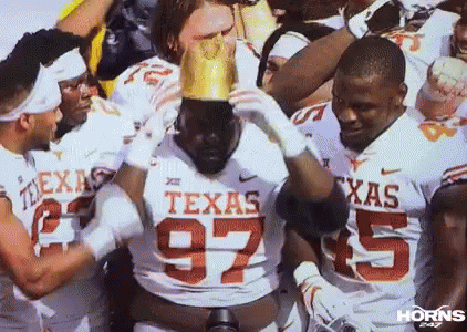 Texas Football Players Holding Crown on Head
