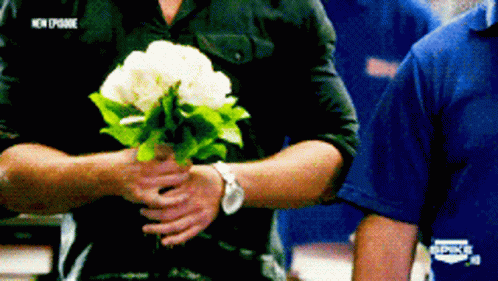 Thad Castle Alan Ritchson Holding Bouquet Of Flowers GIF