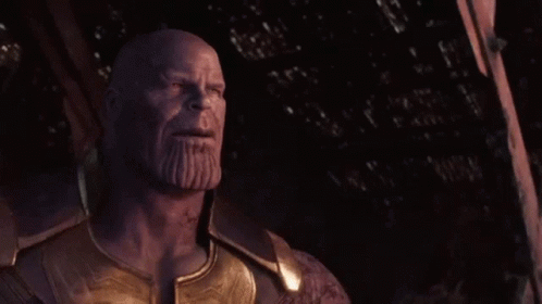 Thanos From Avengers : Age Of Ultron Is Standing In The Dark With His Eyes Closed And A Beard . GIF