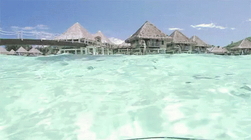 Thatched Huts on Dock in Ocean