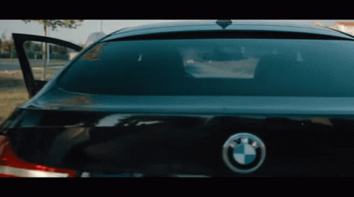 The Back Of A Black Bmw With The Door Open And A Bmw Logo GIF