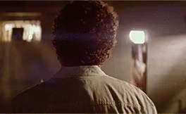The Back Of A Man 'S Head Is Shown In A Dark Room . GIF