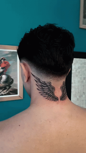 The Back Of A Man 'S Neck Has A Tattoo Of Wings On It GIF