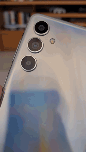 The Back Of A Silver Phone With Three Cameras GIF