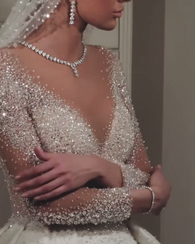 The Bride Is Wearing A Necklace And Earrings And A Veil GIF