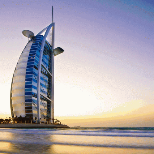 The Burj Khalifa Is A Very Tall Building Sitting On Top Of A Beach GIF