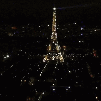 The Eiffel Tower Is Lit Up At Night GIF