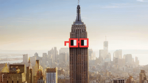 The Empire State Building Is Surrounded By A City Skyline And Has A Pair Of Red Glasses On The Top Of It GIF