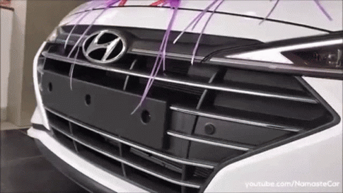 The Front Of A White Hyundai Car With Purple Ribbons GIF