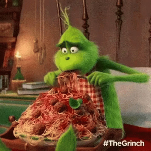 The Grinch From The Movie The Grinch Is Eating Spaghetti And Meatballs With A Fork . GIF