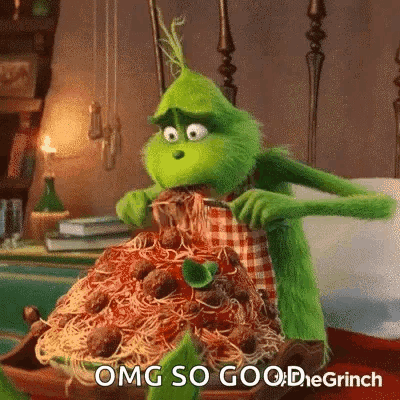 The Grinch From The Movie The Grinch Is Eating Spaghetti And Meatballs With A Fork And Knife . GIF
