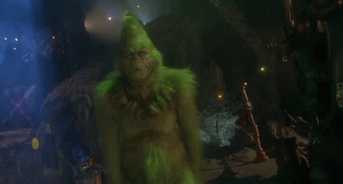 The Grinch From The Movie The Grinch Is Looking At The Camera With His Mouth Open . GIF