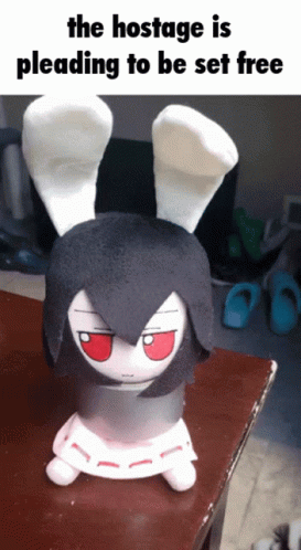 The Hostage Is Pleading To Be Set Free With A Stuffed Bunny On A Table GIF