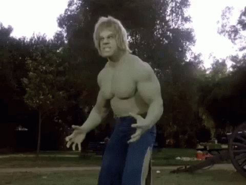 The Hulk Is Standing In A Park With His Arms Outstretched . GIF