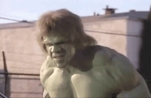 The Hulk Is Standing In Front Of A Building With A Serious Look On His Face . GIF