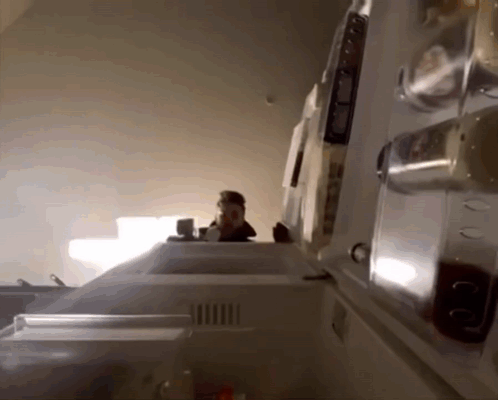 The Inside Of A Refrigerator With The Door Open And A Person Standing Behind It GIF