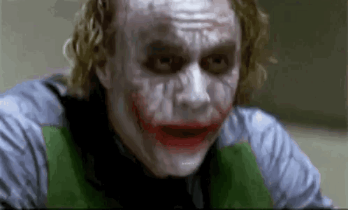 The Joker From The Movie The Dark Knight Is Making A Funny Face While Looking At The Camera . GIF