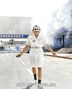 The Joker Is Dressed As A Nurse And Is Walking Down The Street . GIF