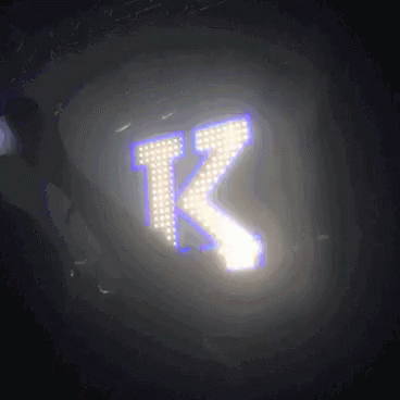 the letter k is glowing in the dark with a purple background