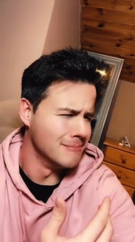 The Man Is Wearing A Pink Hoodie And Making A Funny Face GIF