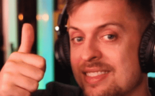 The Man Is Wearing Headphones And Giving A Thumbs Up GIF