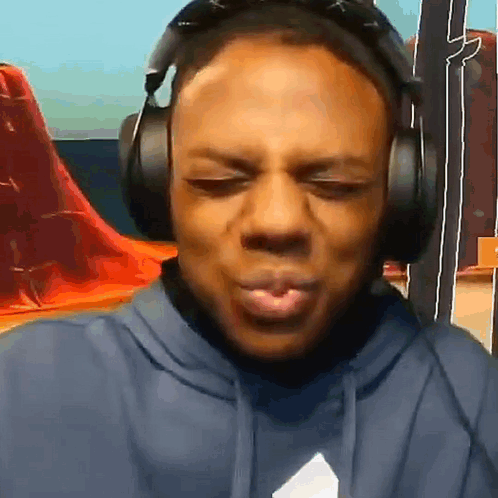 The Man Is Wearing Headphones And Making A Funny Face . GIF